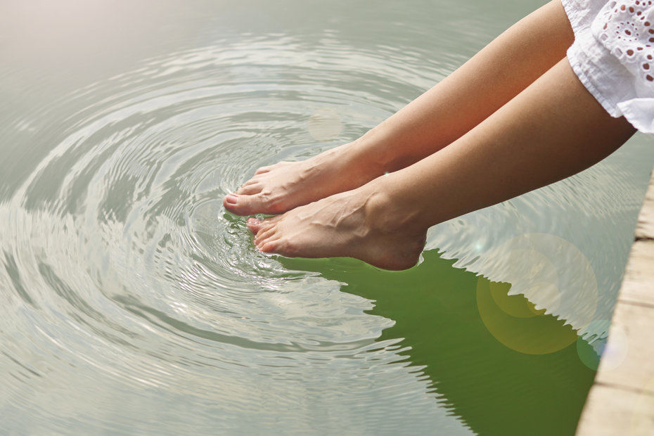 Frau hält Füße ins Wasser