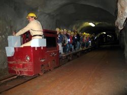 Besucher fahren mit einer Grubenbahn