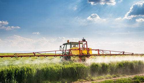Ein Traktor bringt Pflanzenschutzmittel aus Ein Traktor bringt Pflanzenschutzmittel aus
