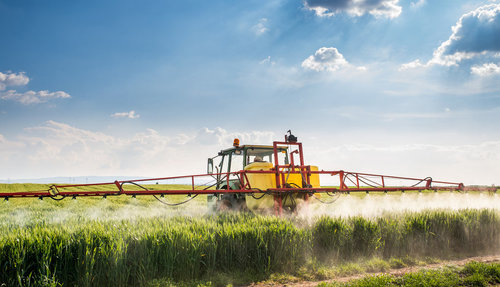 Ein Traktor bringt Pflanzenschutzmittel aus