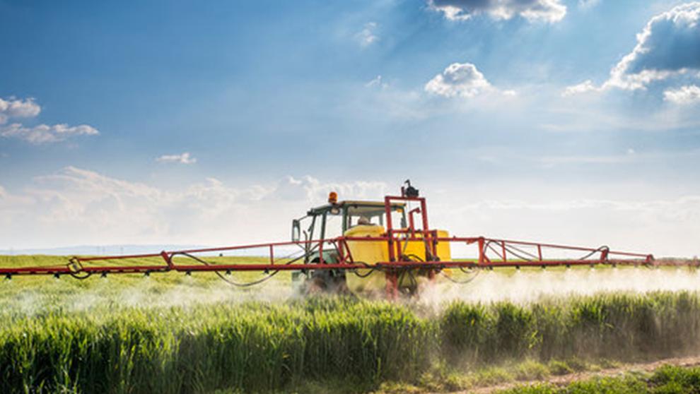 Ein Traktor bringt Pflanzenschutzmittel aus Ein Traktor bringt Pflanzenschutzmittel aus