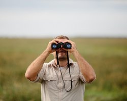 Mann mit Fernglas in der Natur
