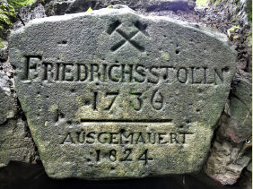 In den Schluss- oder Scheitelstein eines Stollenportals wurden oftmals wichtige betriebliche Daten eingraviert. Scheitelstein Stollenportal Friedrichsstollen